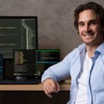 A Shopify developer at a desk with a computer and monitor