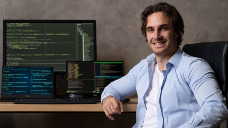 A Shopify developer at a desk with a computer and monitor
